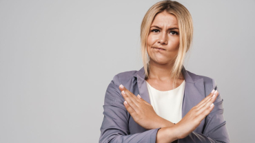 A Woman With A Displeased Expression, Making An "X" Sign With Her Arms