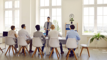 Group Of People Sitting Around A Table